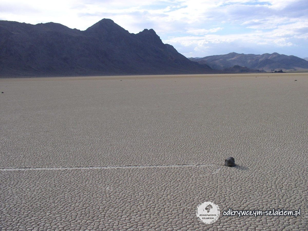 A lone rock and the trail of its journey across the dry bed of Racetrack Playa in Death Valley
