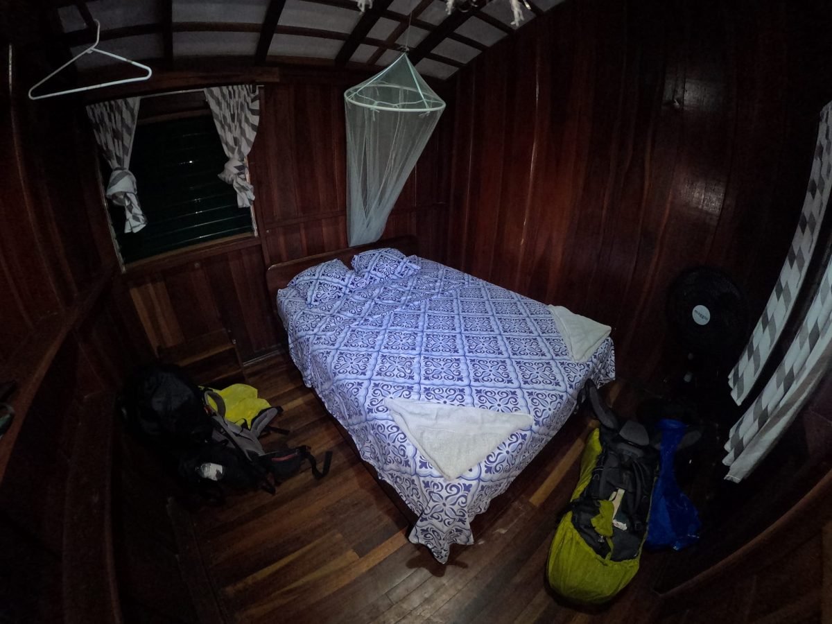 Prosty drewniany pokój z moskitierą nad łóżkiem i wiatrakiem – jeden z noclegów w Kostaryce
