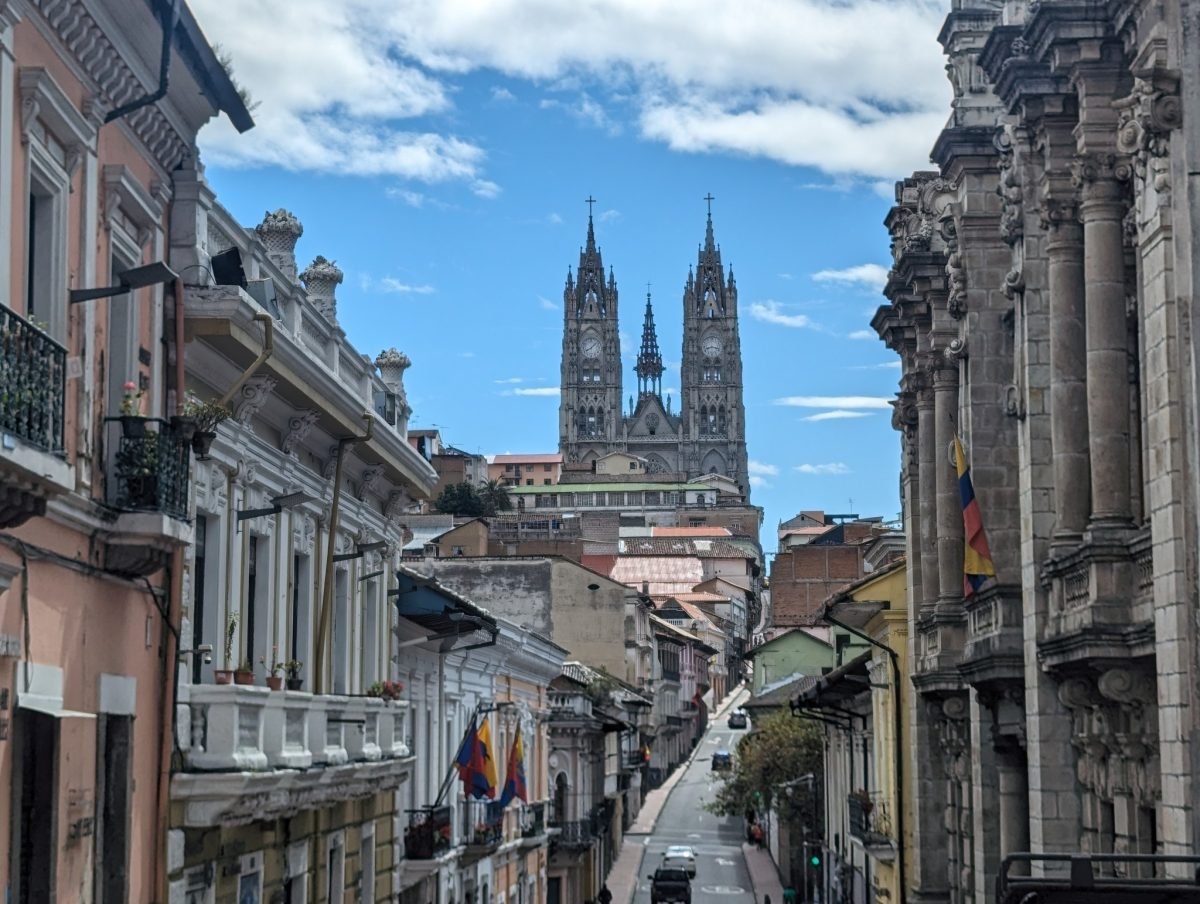Ulica starego miasta w Quito z kamienicami i widokiem na wieże Bazyliki Głosowania Narodowego