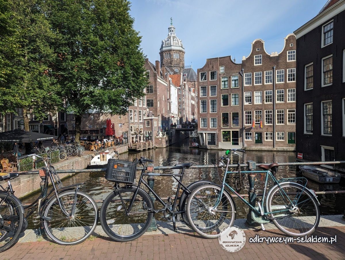 The Oudezijds Voorburgwal canal in Amsterdam with bikes on the bridge, gabled houses and the dome of St Nicholas Basilica