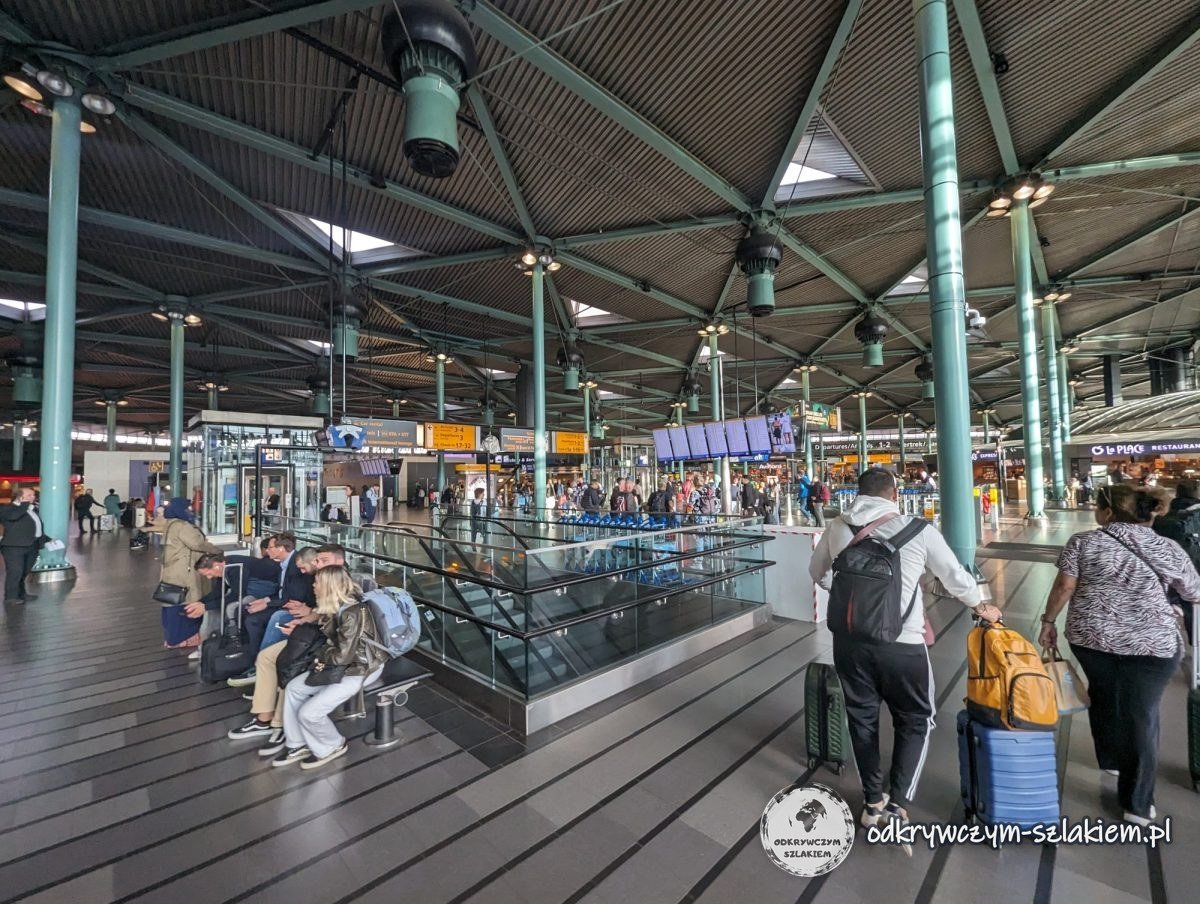 The Schiphol Plaza hall at Amsterdam airport with travellers and green columns