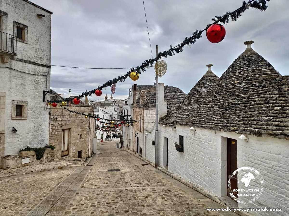 Ulica z trullami w Alberobello z girlandą i czerwonymi bombkami