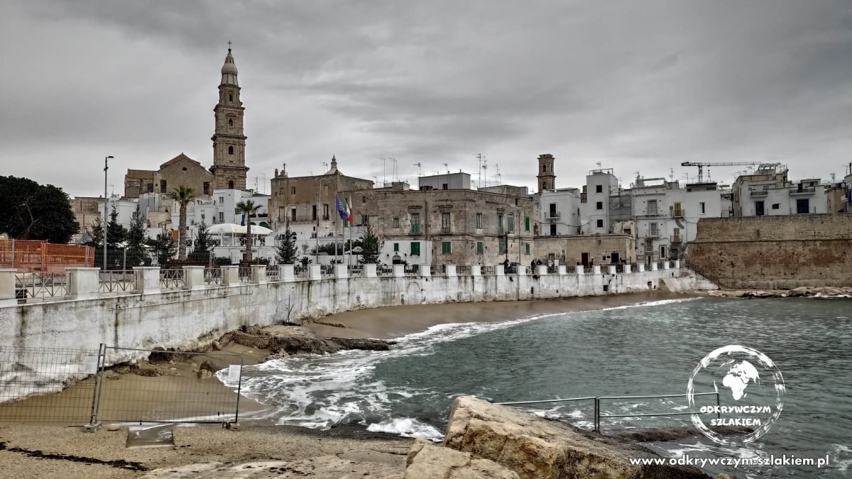 Mury Monopoli nad plażą Cala Porta Vecchia, w tle wieża katedry