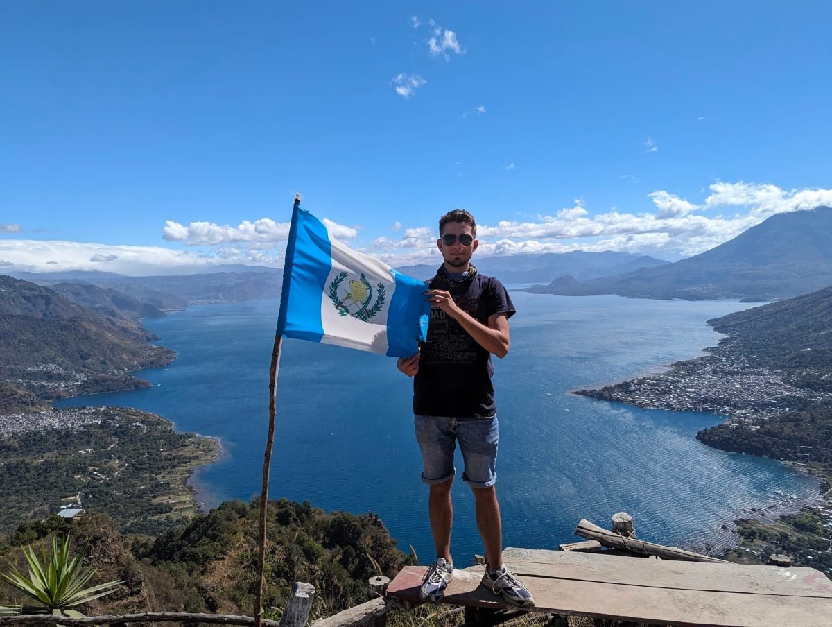 Z flagą Gwatemali na szczycie Indian Nose, w tle jezioro Atitlán
