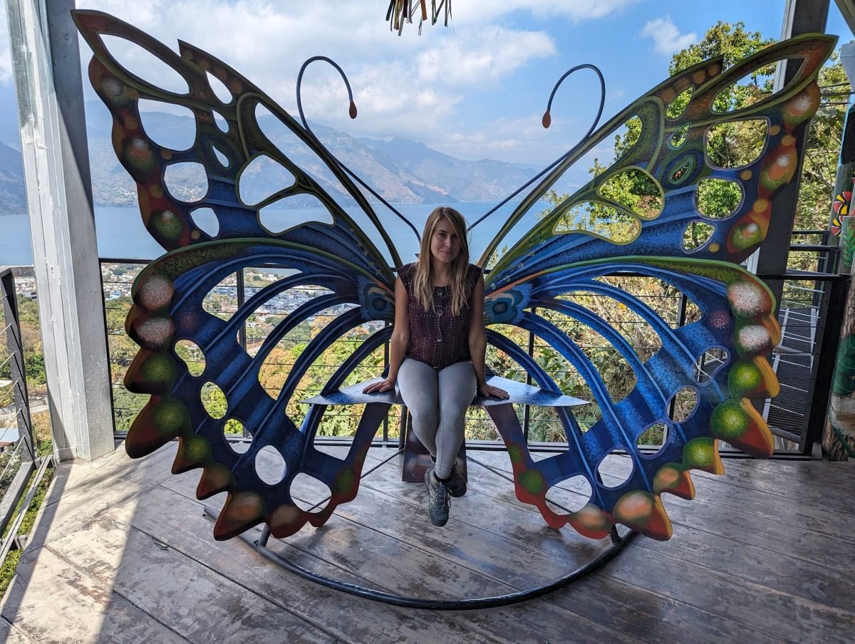 Patrycja na ławce w kształcie motyla w punkcie widokowym Nido del Colibrí, w tle jezioro Atitlán