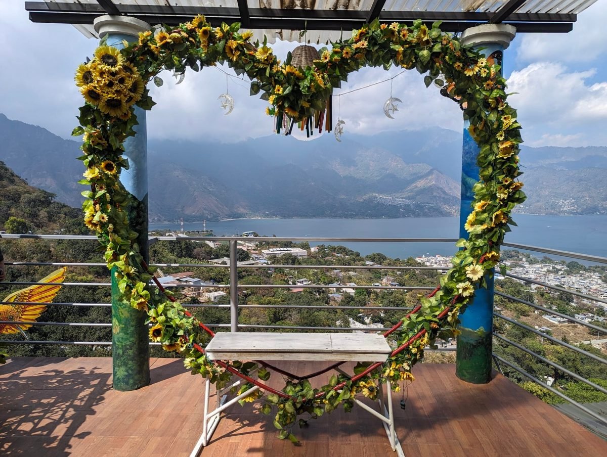 Ławka w kwietnej ramie w kształcie serca w punkcie widokowym Nido del Colibrí z widokiem na San Pedro La Laguna i jezioro Atitlán