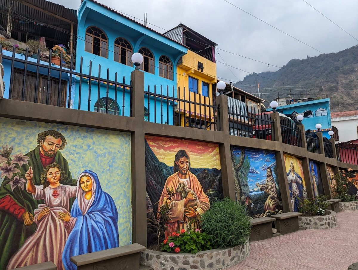 Murale z motywami religijnymi pod kolorowymi domami w Santa Cruz La Laguna