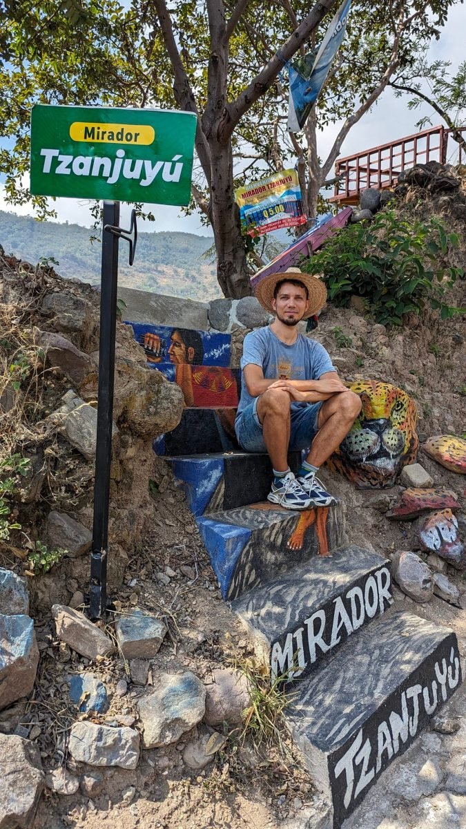 Na pomalowanych schodach punktu widokowego Mirador Tzanjuyú w Santa Cruz La Laguna, obok tablica z nazwą i kamień pomalowany w jaguara