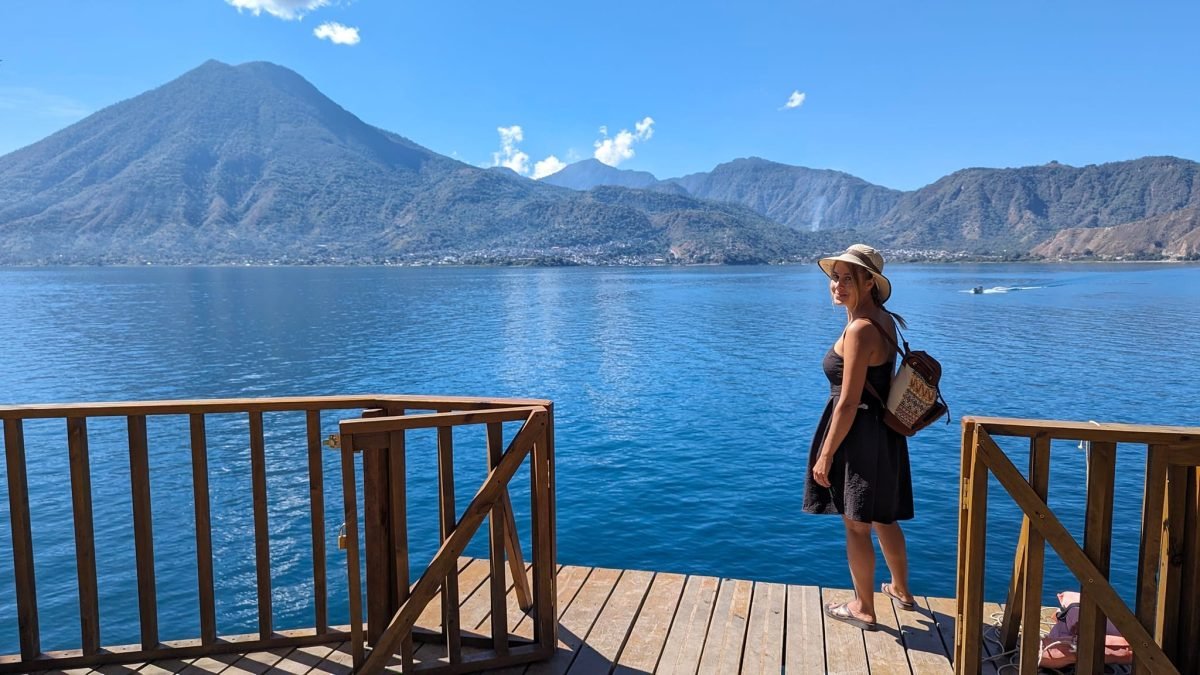 Patrycja na drewnianym pomoście nad wodą w rezerwacie Cerro Tzankujil, w tle wulkan San Pedro
