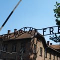The gate with the “Arbeit macht frei” sign and a brick block in the former Auschwitz I camp