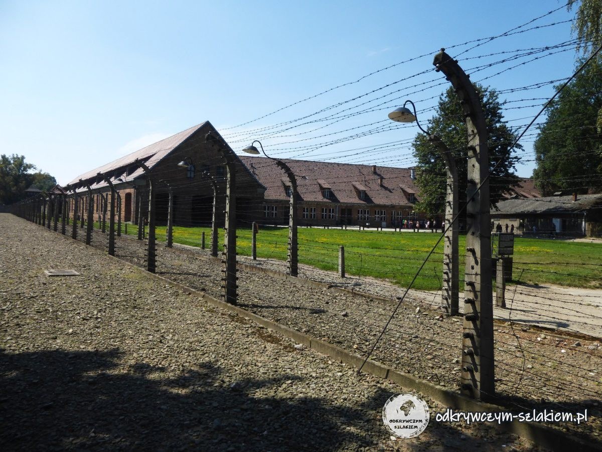 Postes de la alambrada con púas y farolas junto a los bloques de Auschwitz I