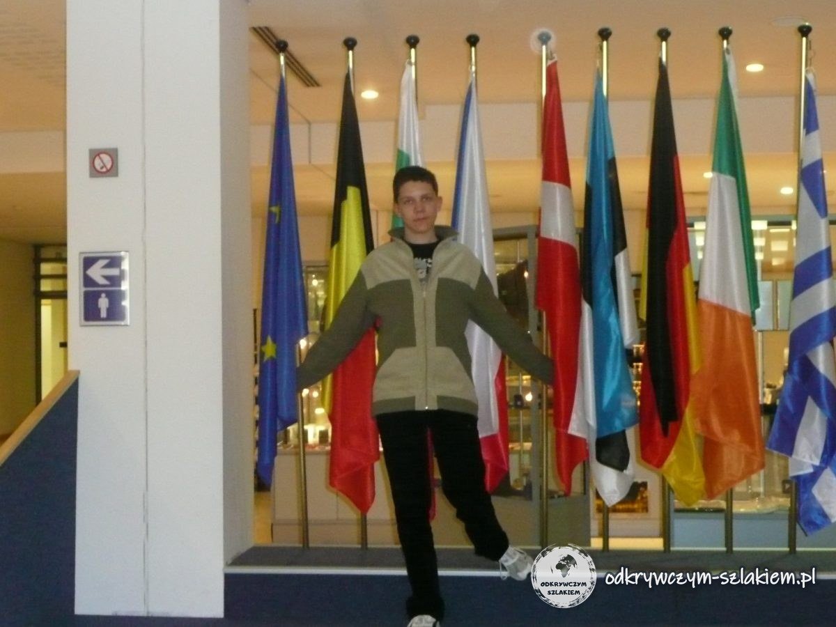 Turysta przed rzędem flag państw Unii Europejskiej w Parlamencie Europejskim