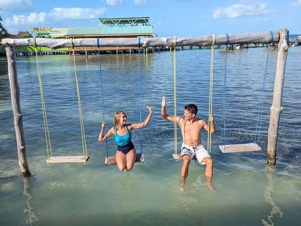 Huśtawki w turkusowej wodzie na wyspie Caye Caulker, Belize
