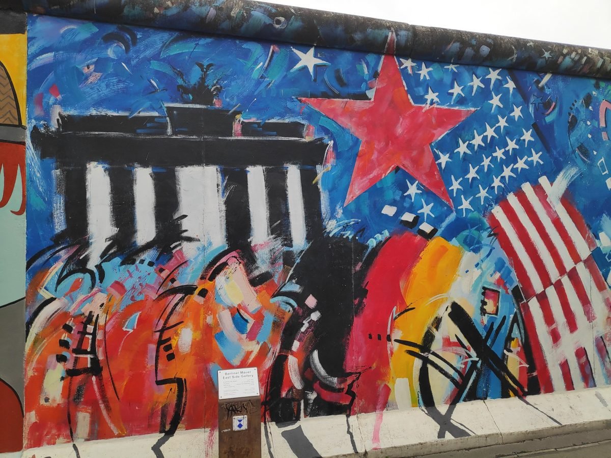 Mural z Bramą Brandenburską i flagami na East Side Gallery
