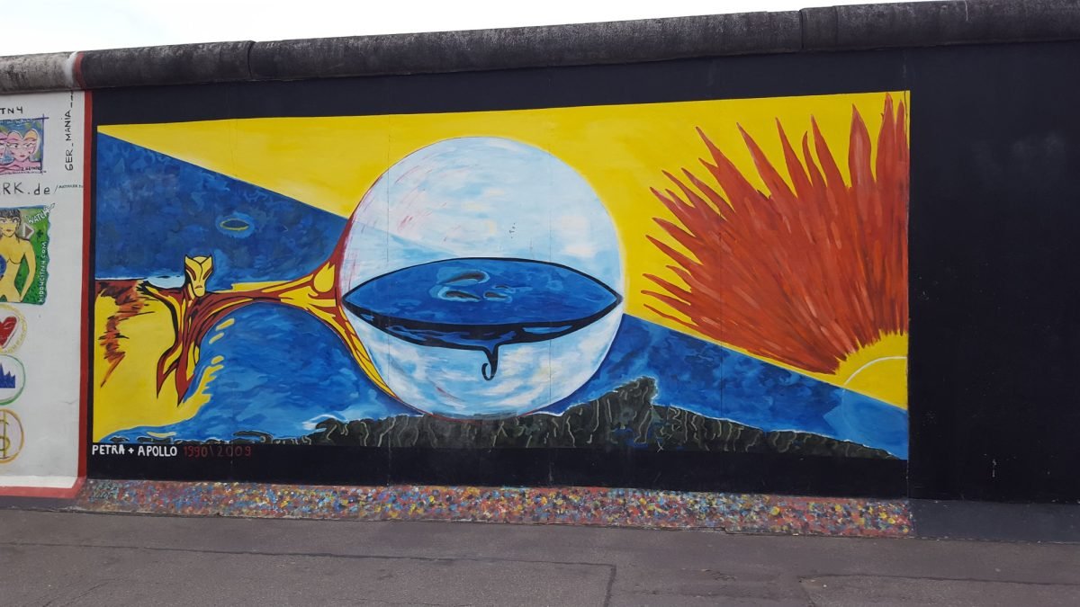 Mural z kulą ziemską i promieniami na East Side Gallery