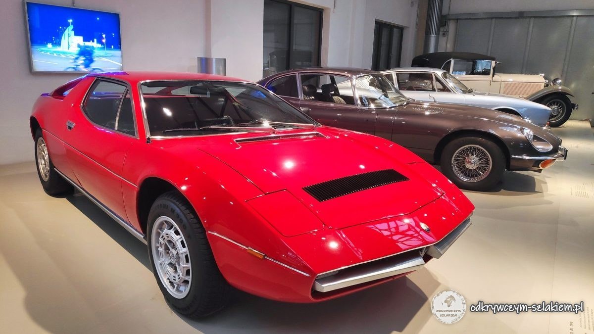 Samochody sportowe, m.in. czerwone Maserati, w Muzeum Techniki
