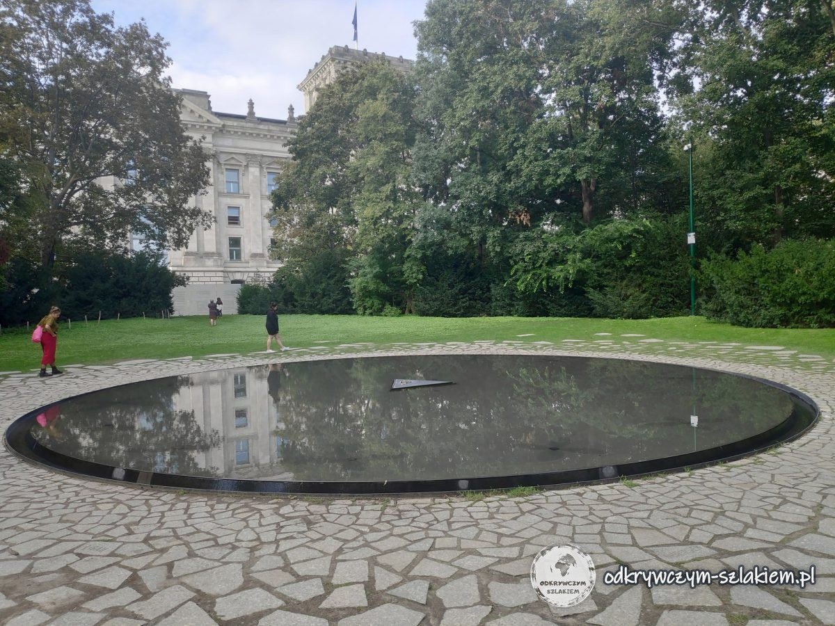 Round pool with a triangular stone in the middle – the Memorial to the Sinti and Roma by the Reichstag
