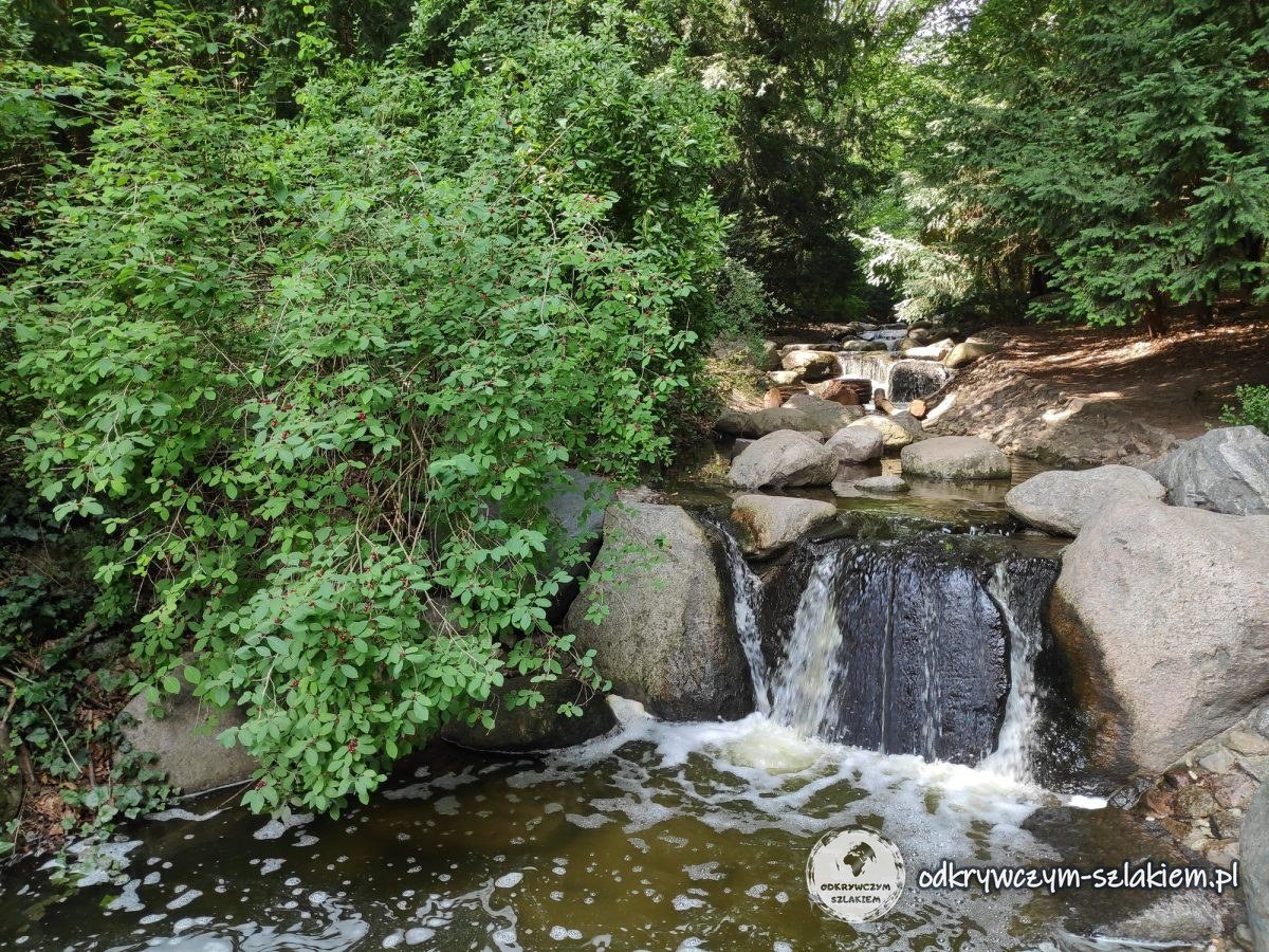 Der Wasserfall über Findlinge im Steinbergpark im Sommer