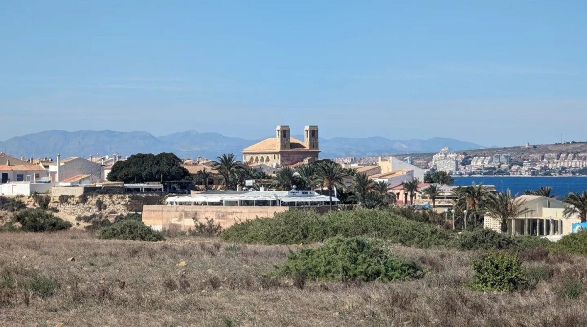 Zabudowa wyspy Tabarca z kościołem, w tle wybrzeże Costa Blanca i góry