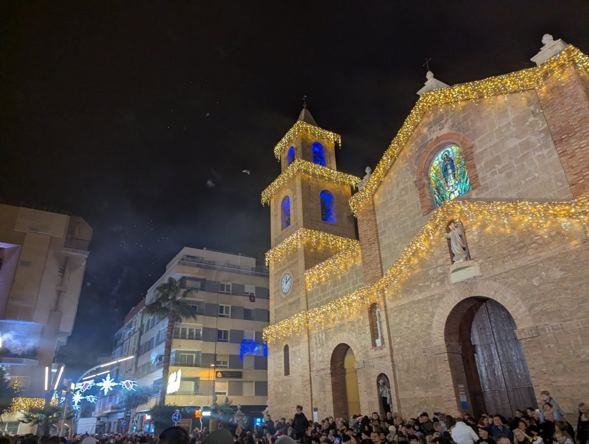 Kościół w centrum Torrevieja oświetlony girlandami w noc sylwestrową, z tłumem na placu
