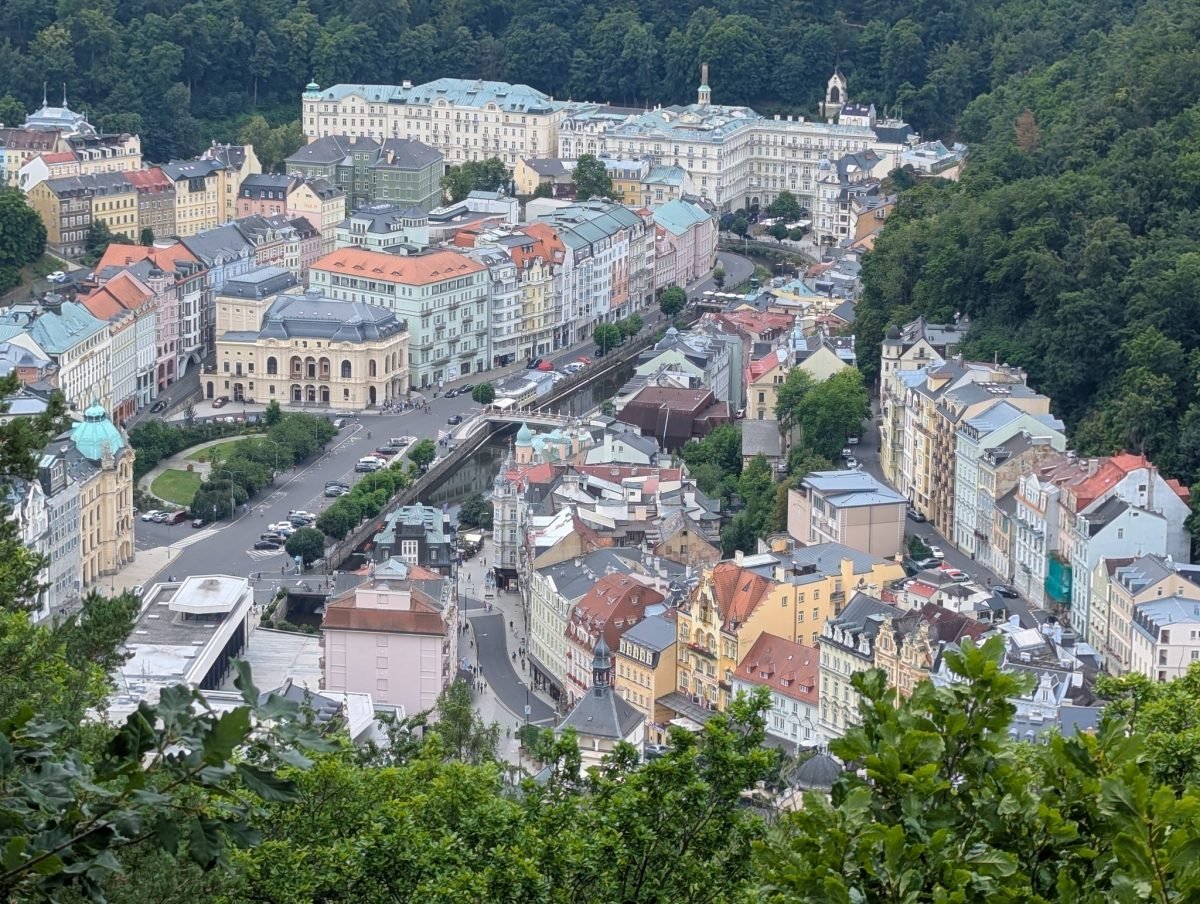 Panorama Karlowych Warów z punktu widokowego na wzgórzu – kolorowe kamienice w dolinie rzeki Teplá