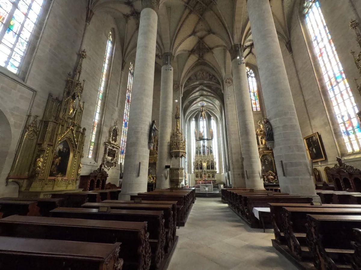 Wnętrze katedry św. Bartłomieja w Pilźnie – smukłe filary, witraże i ołtarz główny