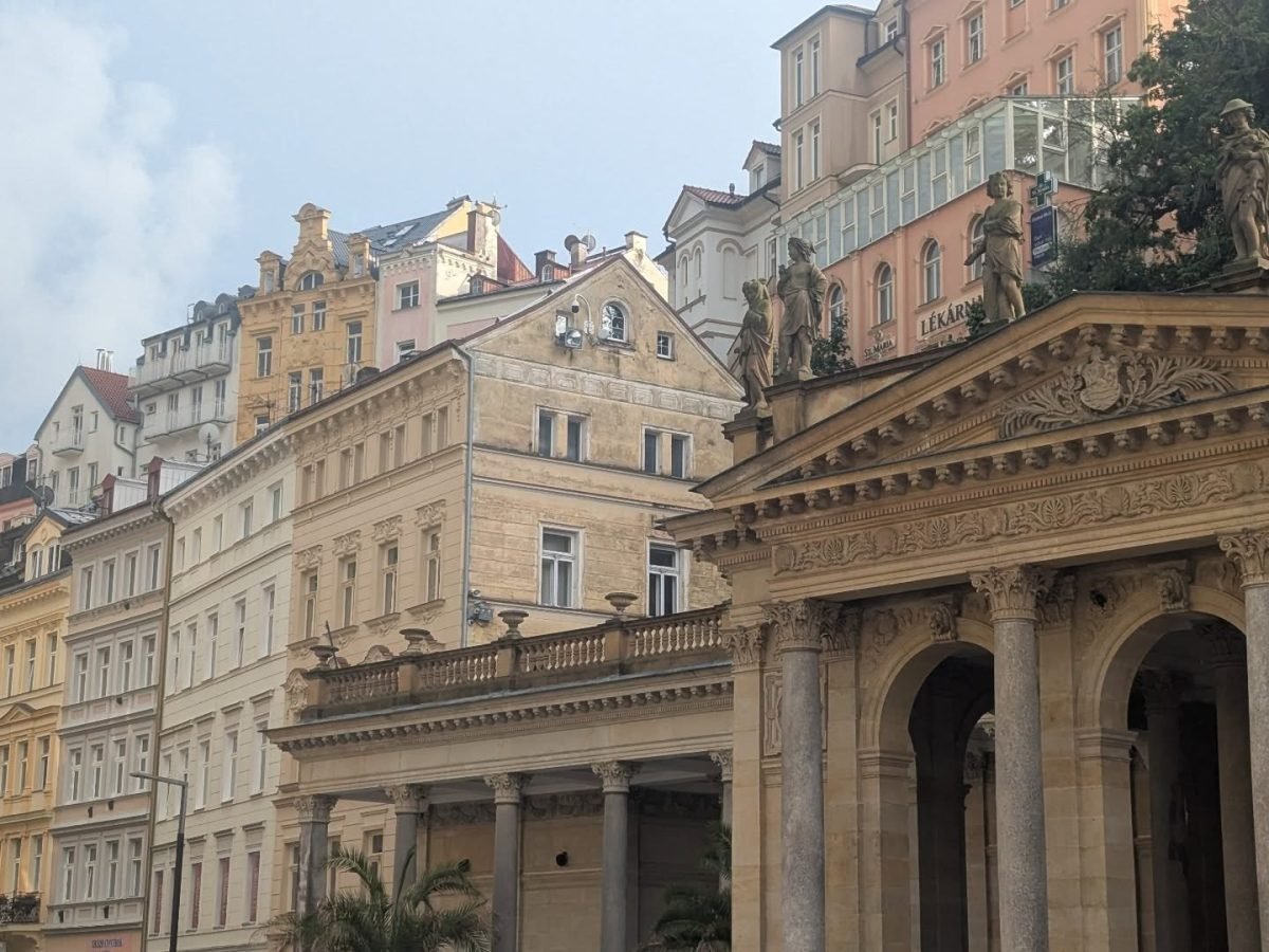 Kolumny i rzeźby Kolumnady Młyńskiej na tle kamienic w Karlowych Warach