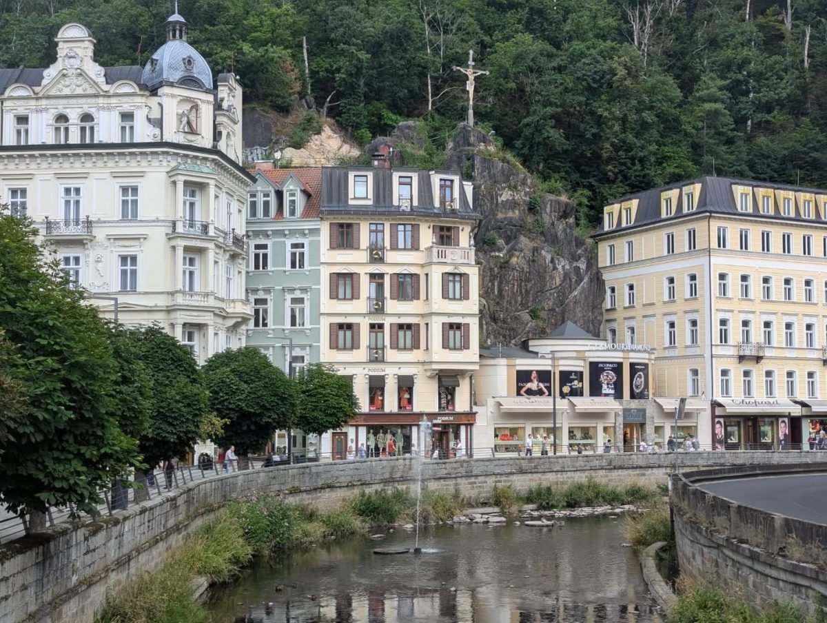 Fontanna na rzece Teplá, kamienice i krzyż na skale nad Karlowymi Warami