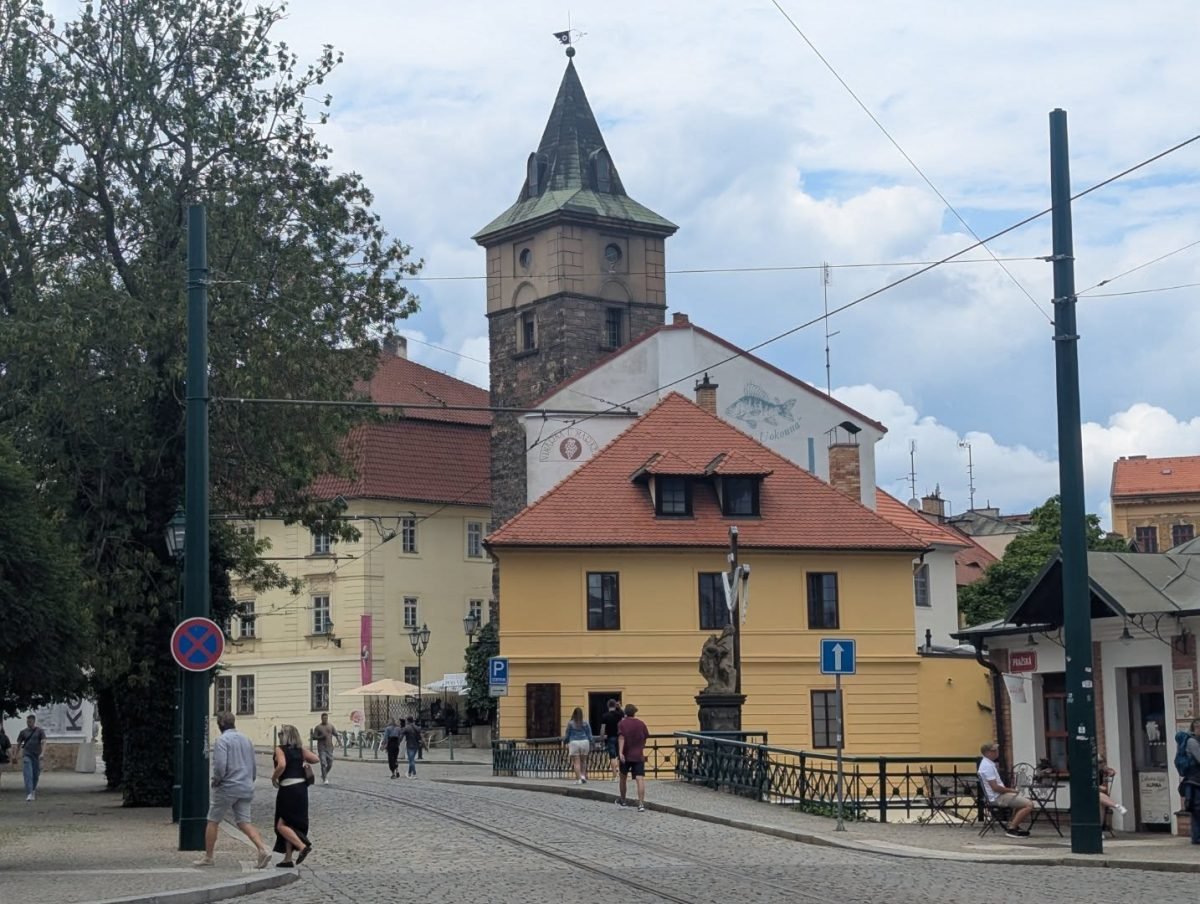 Ulica w centrum Pilzna z wieżą nad dachami i torami tramwajowymi