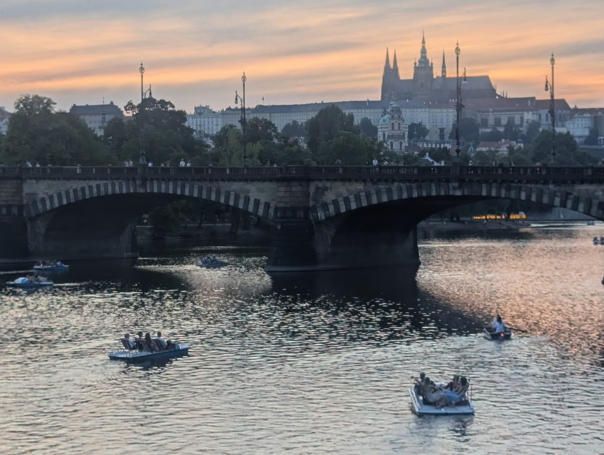 Hradczany z katedrą św. Wita nad Mostem Legii o zachodzie słońca, na Wełtawie rowerki wodne