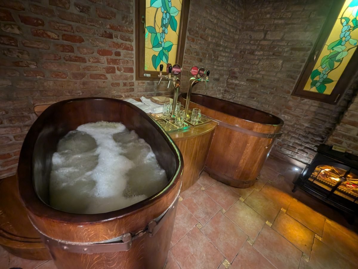 Drewniana kadź z pianą i krany z piwem w piwnym spa w Pradze