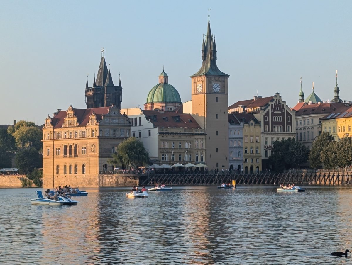 Staromiejski brzeg Wełtawy z wieżą mostową, kopułą i wieżą ciśnień o złotej godzinie
