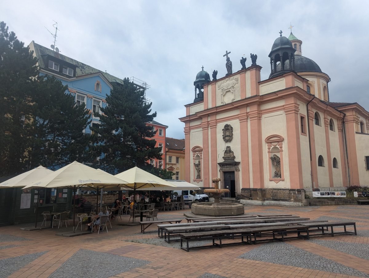 Plac w centrum Děčína z barokowym kościołem i ogródkami restauracji