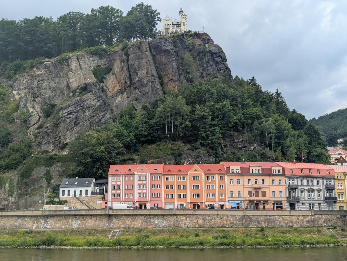 Skalna ściana Pastýřská stěna z budynkiem na szczycie, pod nią kamienice nad Łabą