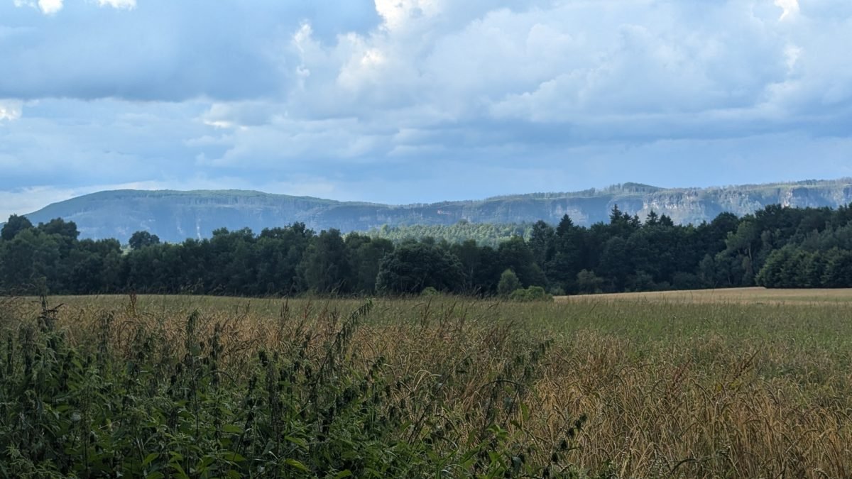 Pola i las na tle długiej, płaskiej góry stołowej na horyzoncie