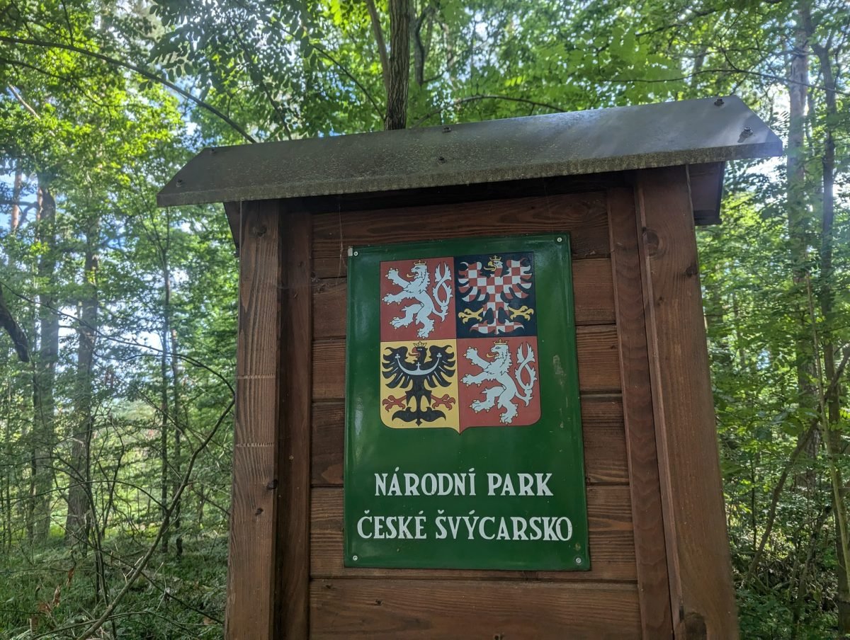 Tablica z godłem Czech i napisem Národní park České Švýcarsko przy szlaku
