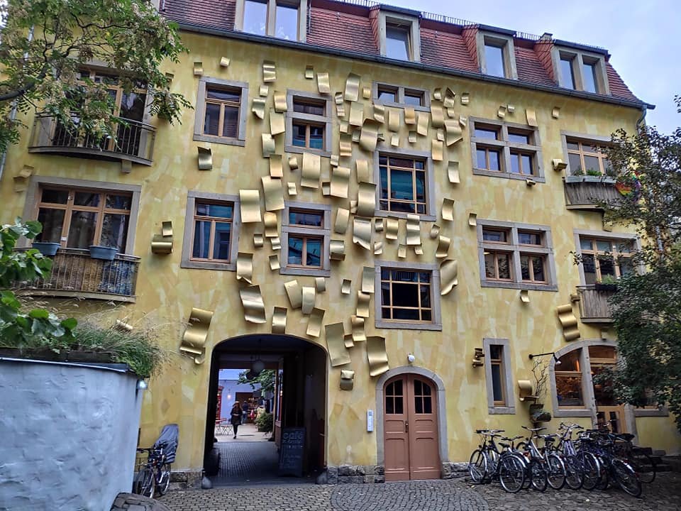 Żółta kamienica ze złotymi ozdobami w pasażu Kunsthofpassage w Dreźnie