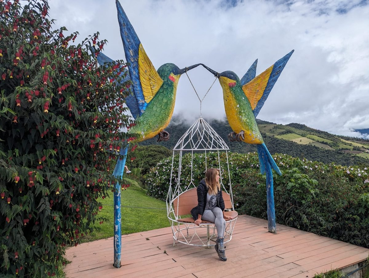 Patrycja na siedzisku między dwiema dużymi figurami kolibrów na tarasie widokowym przy La Casa del Árbol