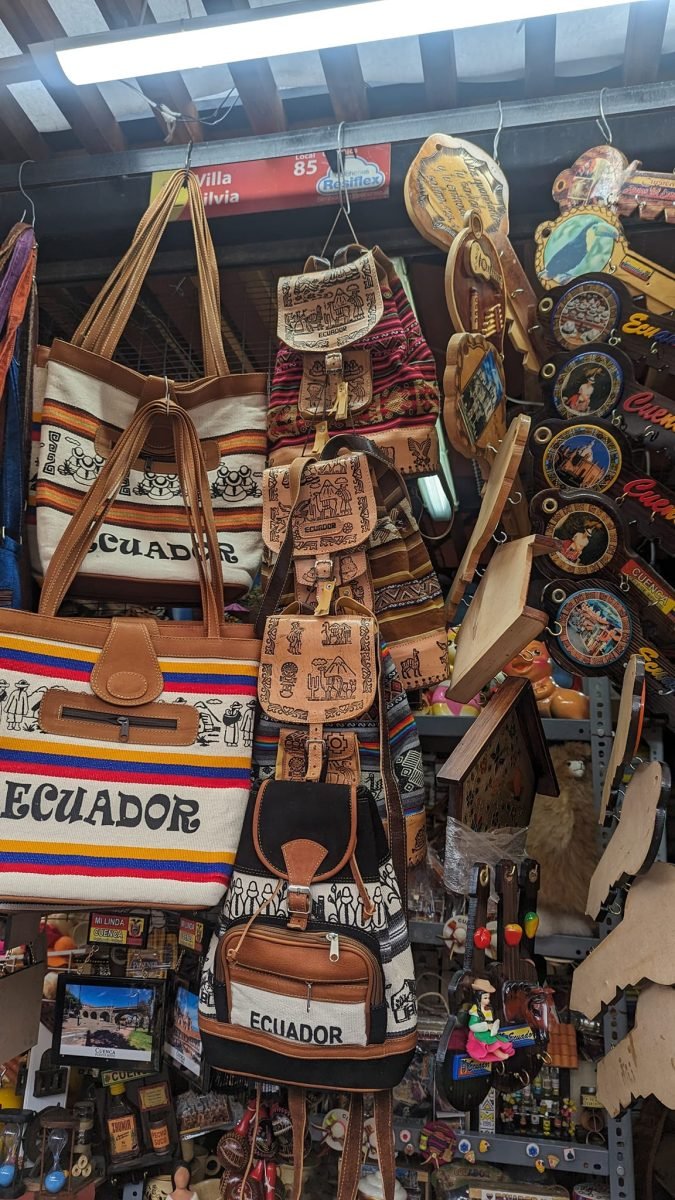 Kolorowe torby i plecaki z napisem Ecuador na straganie z pamiątkami w Cuenca