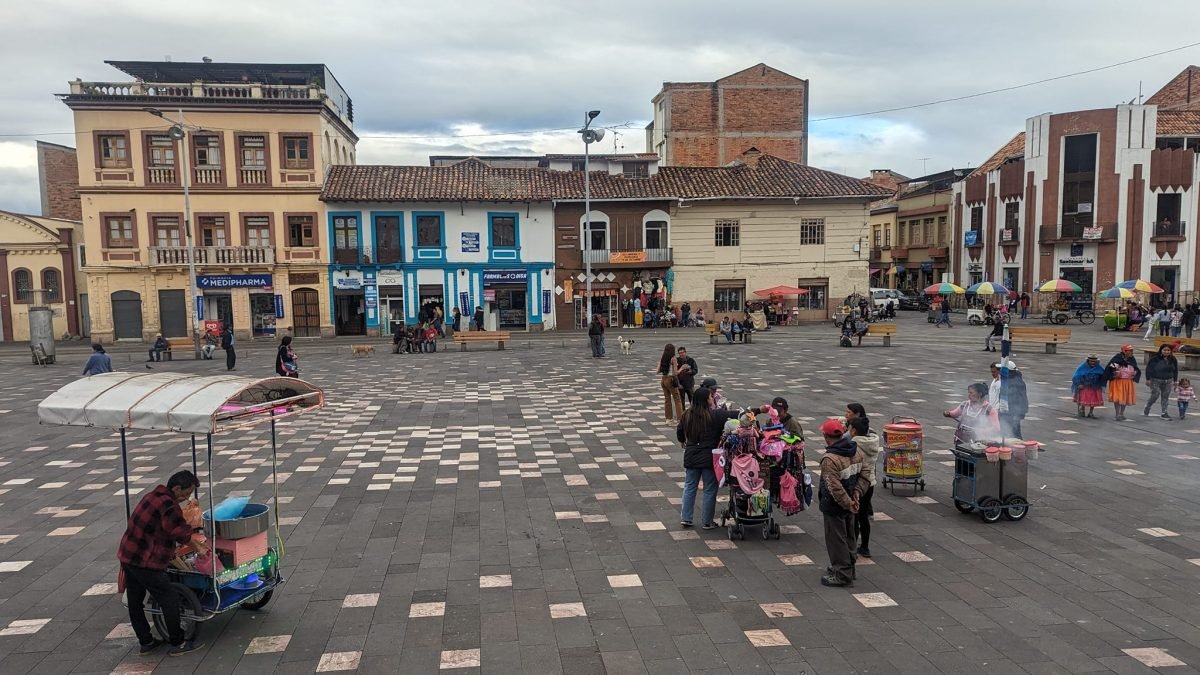 Plac w Cuenca z wózkami ulicznych sprzedawców, w tle kolorowe kamienice
