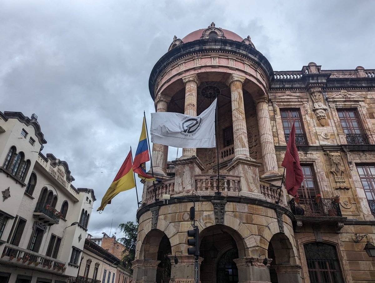 Kamienica z kolumnową rotundą na narożniku i flagami w centrum Cuenca