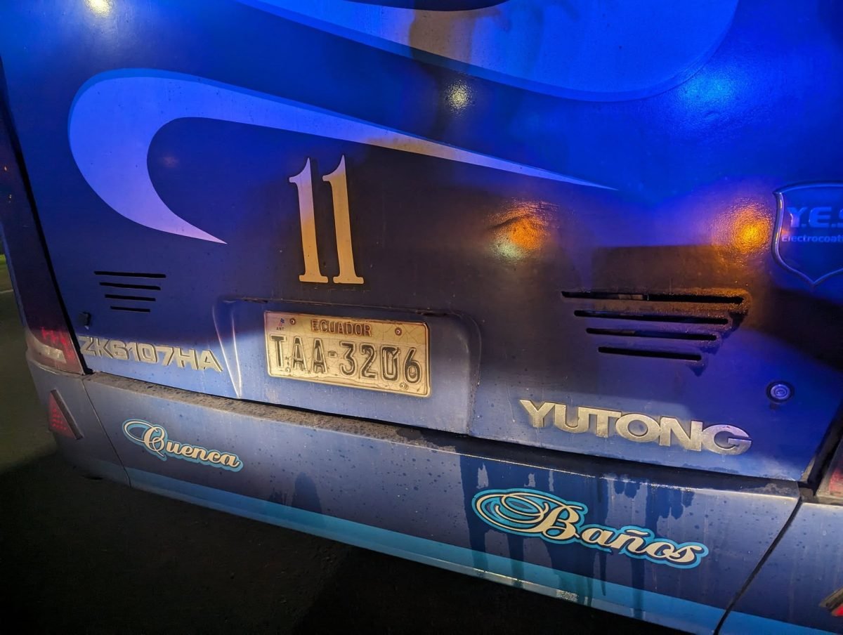 Tył niebieskiego autobusu Yutong z numerem 11 i napisami Cuenca i Baños, nocą na dworcu w Baños