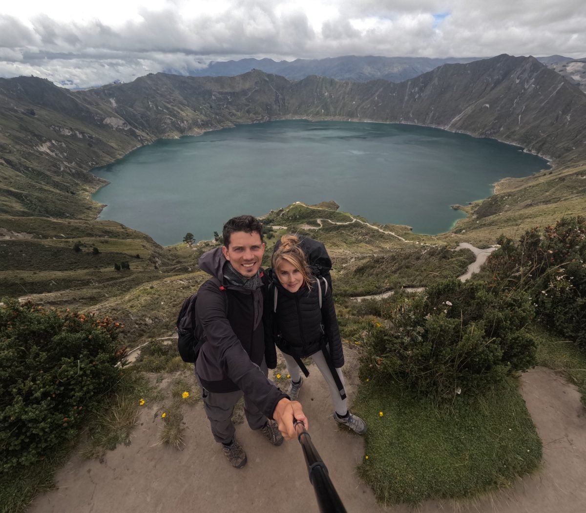 Maciek i Patrycja nad laguną Quilotoa, w tle krater wulkanu i ścieżka wzdłuż krawędzi
