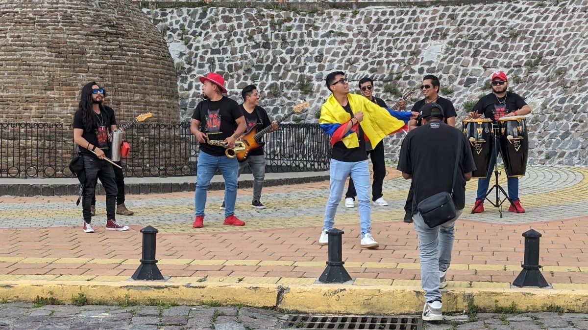 Uliczny zespół grający przy kamiennym murze w Quito