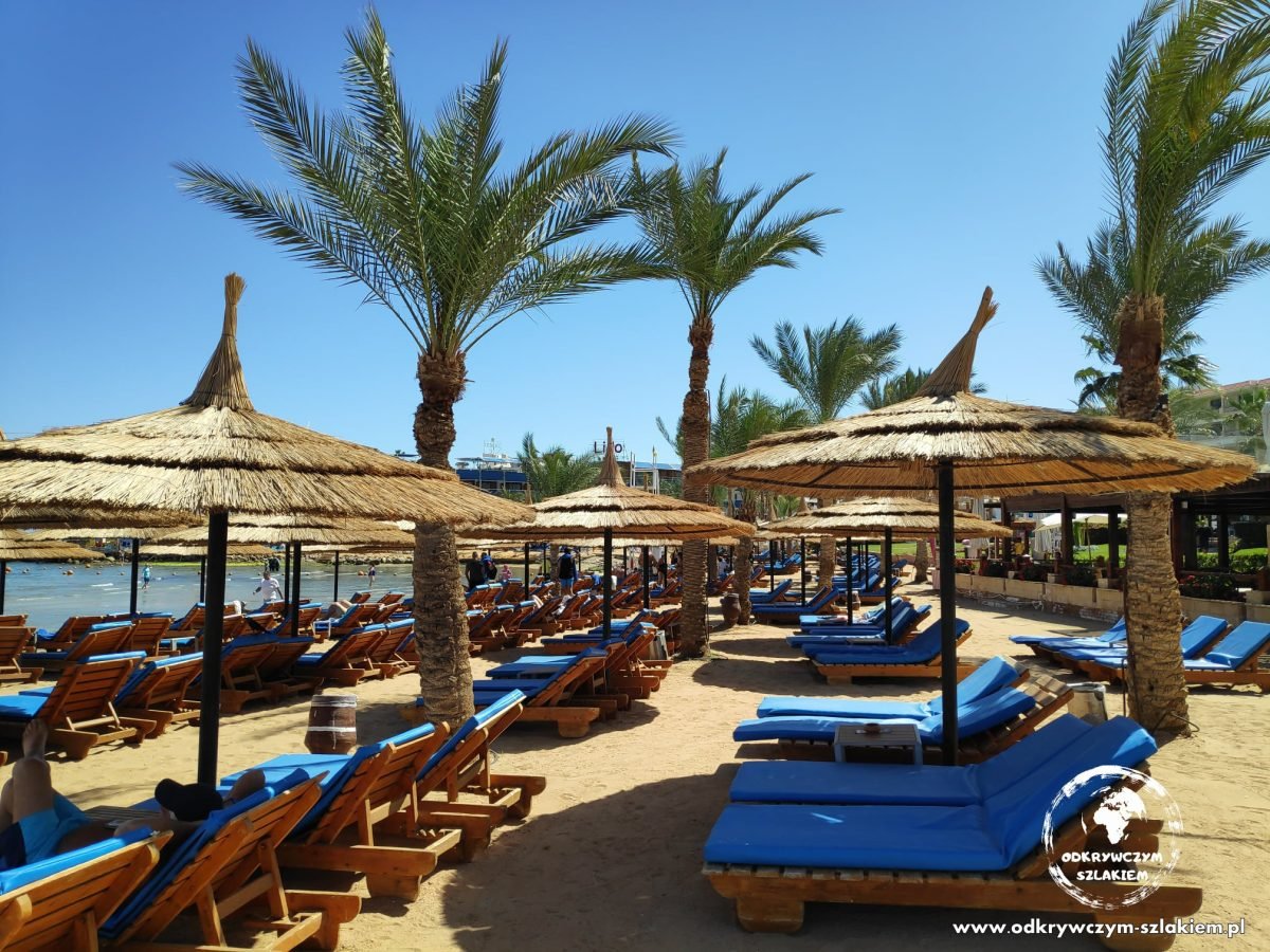 Plaża z leżakami i parasolami z liści palmowych w Sharm el-Sheikh
