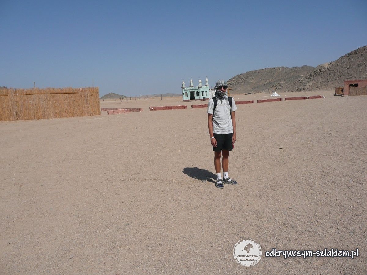 El desierto cerca de Hurghada con montañas detrás y un turista con un pañuelo en la cara
