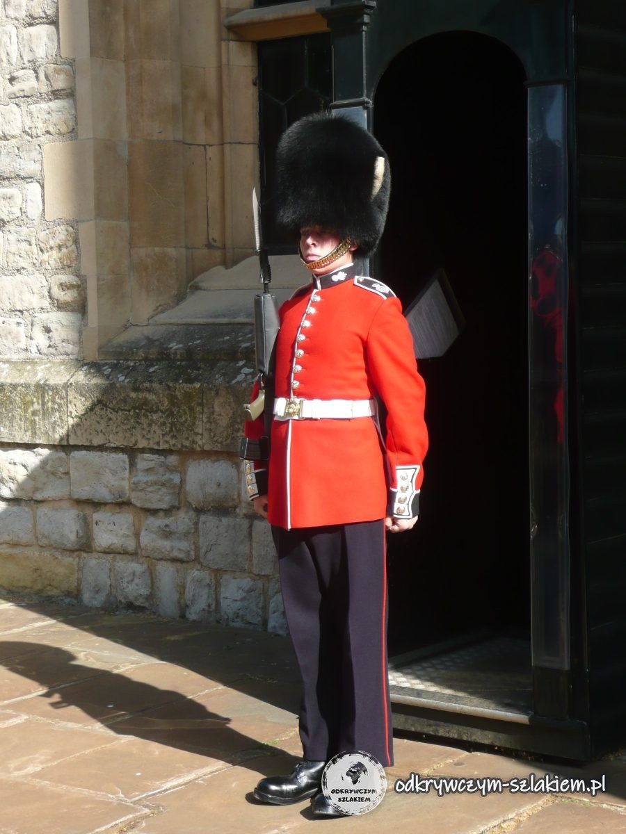 Wartownik w czerwonym mundurze i futrzanej czapie przed budką w Tower of London