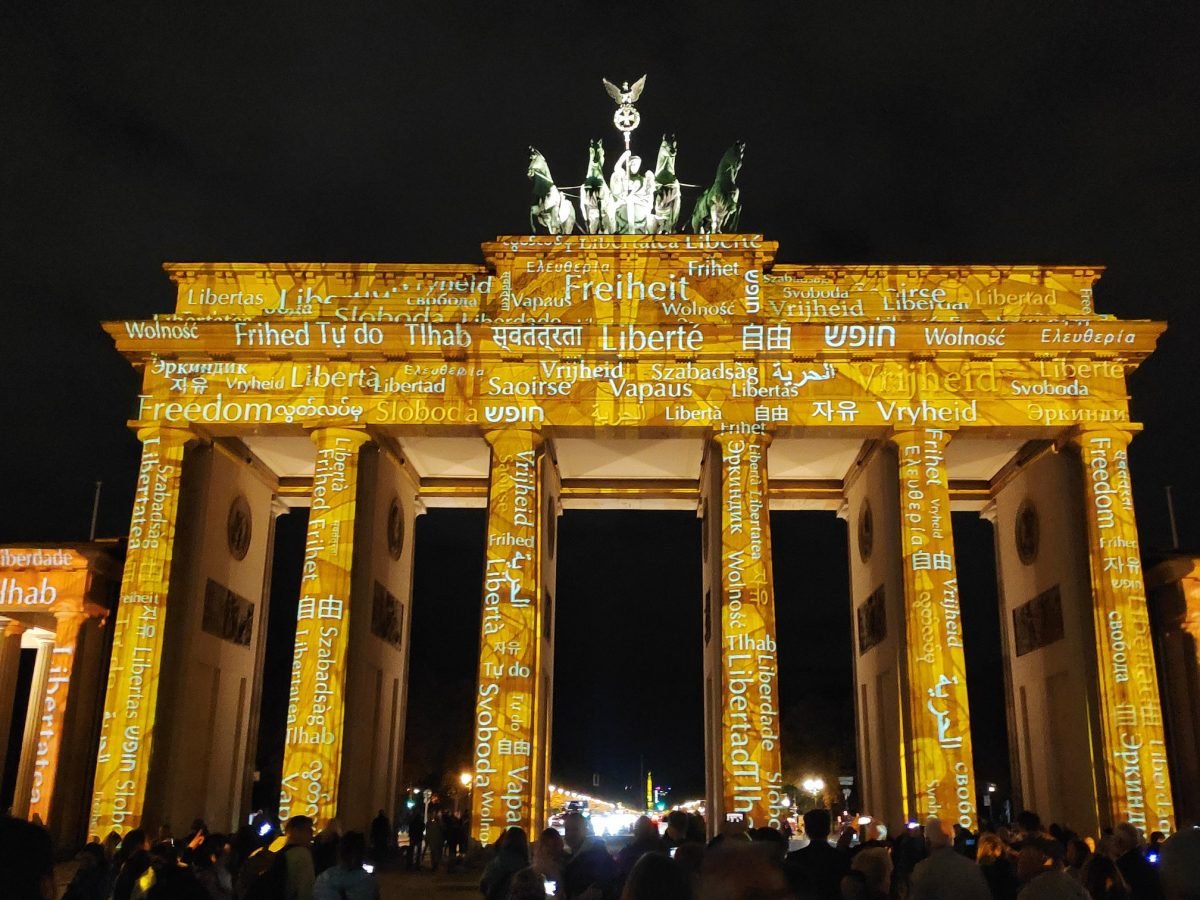 Brama Brandenburska w złotej projekcji ze słowem „wolność” w wielu językach