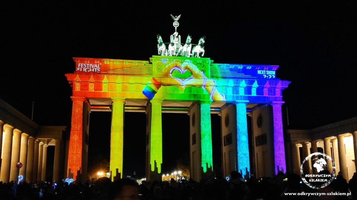Brama Brandenburska w tęczowej projekcji z dłońmi układającymi się w serce (Festival of Lights 2022)