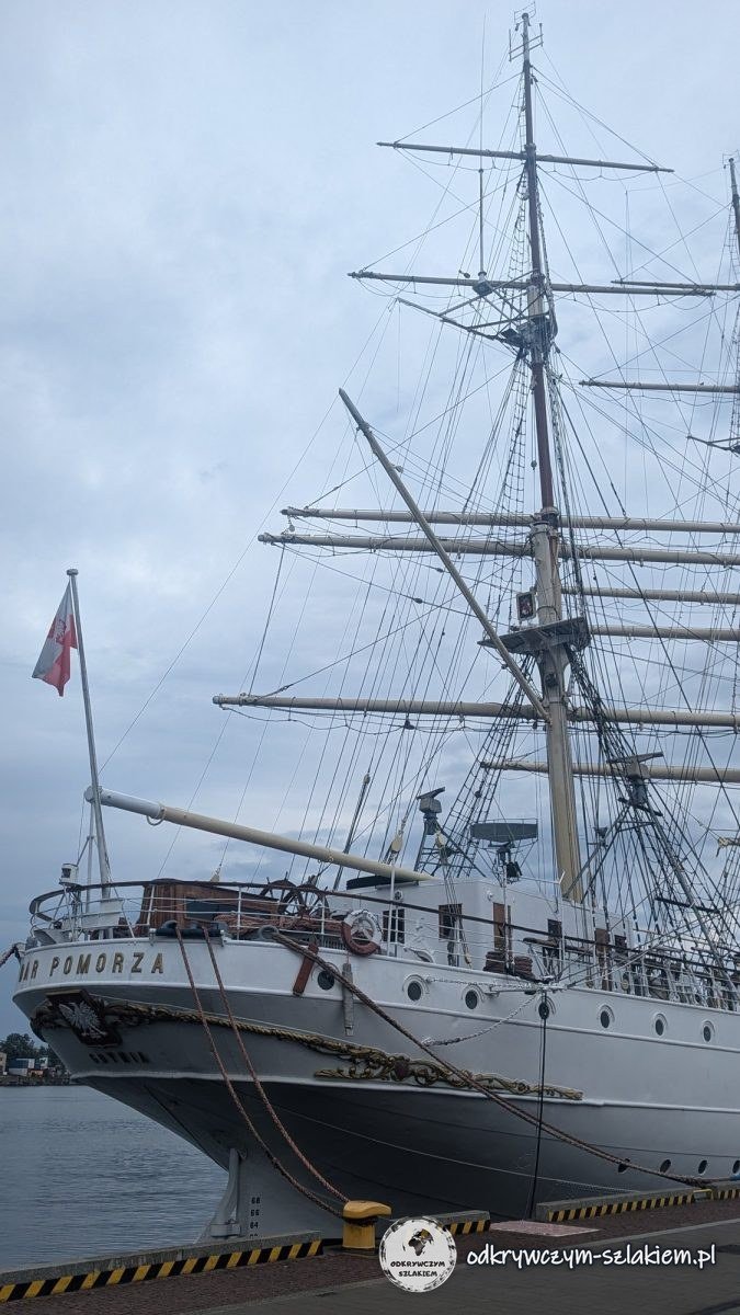 The bow and masts of the sailing ship Dar Pomorza at the quay in Gdynia, with the Polish flag